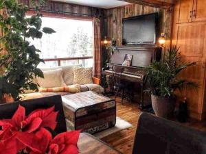 sala de estar con sofá y piano en Biche et Lac, en North Hatley