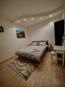 a bedroom with a bed with a rug and a desk at Studio Unikat in Braşov