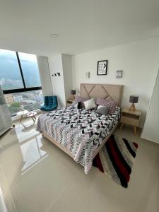 1 dormitorio con cama y ventana grande en Moderno y cómodo apartamento en Puerta del Sol en Bucaramanga