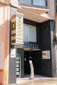 un magasin avec un panneau devant un bâtiment dans l'établissement Apartamentos Doctor Clara, Castellón de la Plana