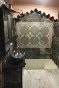 baño con lavabo y pared de piedra en Aladin Comfort Country House, en Campinho