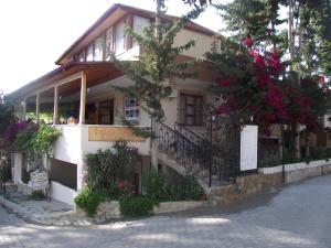 a building with flowers on the side of it at Golden Pension in Patara