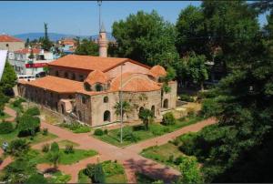 un antiguo edificio con una torre y una iglesia en bungalov ve göl kenarina kurulmuş sahil evi., 