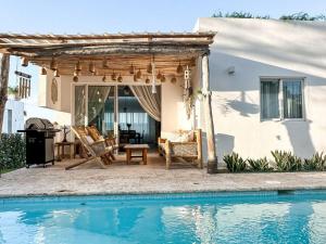 a pergola and a swimming pool in front of a house at Villa Saule in Bombita