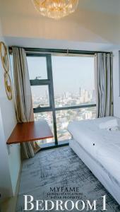 ein Schlafzimmer mit einem Bett und einem großen Fenster in der Unterkunft 2BR SMDC Premium Unit: FAME Residences 31st FLOOR in Manila