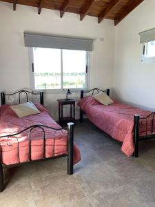 2 Betten in einem Zimmer mit Fenster in der Unterkunft Casa del sol in Cañada La Negra