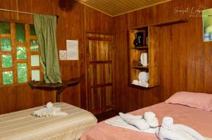 two beds in a room with wooden walls at Sunset Lodge in Drake