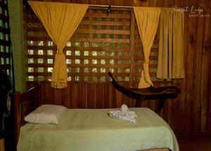 a bedroom with a bed and a chair and a window at Sunset Lodge in Drake