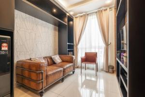 sala de estar con sofá de cuero marrón y silla en Mansion One Executive Studio 2pax, en George Town