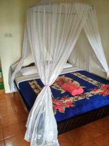a bedroom with a bed with a canopy at Made Homestay Munduk in Munduk