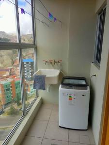 y baño con lavabo y lavadora. en Apartamento en La Paz, en La Paz