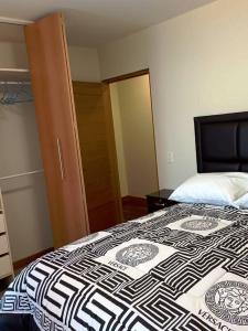 a bedroom with a bed with a black and white quilt at Apartamento en La Paz in La Paz