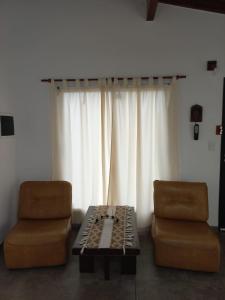a living room with two chairs and a table and a window at Casa del sol in Cañada La Negra