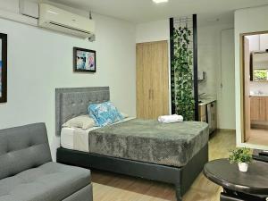 1 dormitorio con cama, sofá y mesa en Apartamento Lleras en Medellín