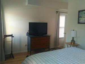 ein Schlafzimmer mit einem Bett und einem TV auf einer Kommode in der Unterkunft The Whitney in Buffalo