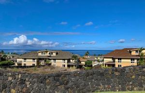 eine Reihe von Häusern hinter einer Steinmauer in der Unterkunft The Best 3bd 3ba Condo Near Ocean with AC Office and Loft ACJ1 in Kailua-Kona