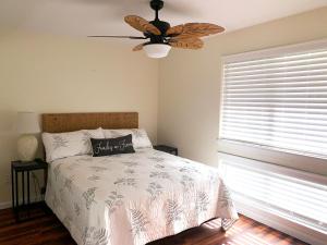 a bedroom with a bed with a ceiling fan and a window at The Best 3bd 3ba Condo Near Ocean with AC Office and Loft ACJ1 in Kailua-Kona +17 photos