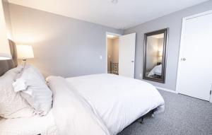 1 dormitorio con cama blanca y espejo en Cheerful home with free parking and WiFi, en Rochester