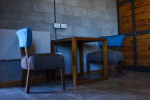 dos sillas sentadas junto a una mesa y un taburete en Mahuida Lodge Valle de Uco en Colonia Las Rosas