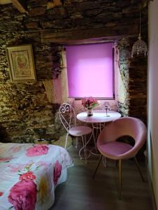 a room with a bed and a table and chairs at Casa da Vita in Ferreira