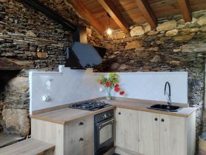 a kitchen with a stove and a stone wall at Casa da Vita in Ferreira +12 photos