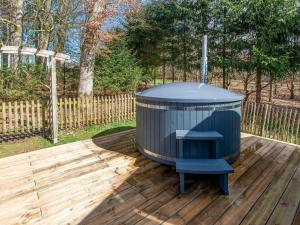 a blue trash can sitting on a wooden deck at Charming house with sauna and Nordic bath in Bullange