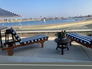2 bancos en un balcón con vistas a la playa en Touch of Heaven, en Long Beach