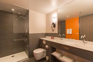 La salle de bains est pourvue de toilettes, d'un lavabo et d'une douche. dans l'établissement Leonardo Hotel Amsterdam Rembrandtpark, à Amsterdam
