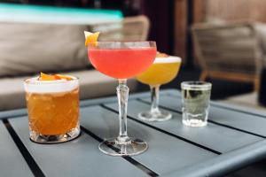 three cocktails sitting on top of a table at Leonardo Hotel Amsterdam Rembrandtpark in Amsterdam