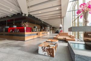 un hall avec des canapés et un bar dans un bâtiment dans l'établissement Leonardo Hotel Amsterdam Rembrandtpark, à Amsterdam