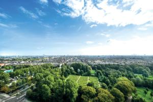 an aerial view of a park with trees and a city at Leonardo Hotel Amsterdam Rembrandtpark in Amsterdam