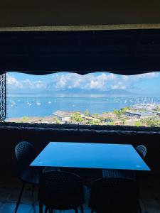 a table with chairs and a view of the ocean at OLotus Studio Punaauia in Punaauia