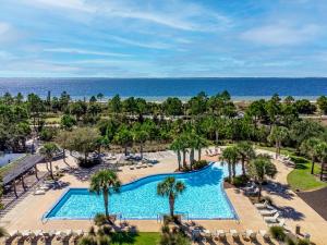 an aerial view of a resort with a pool and the ocean at Minutes to Beach ,Golf Cart Included, Ocean View Pool ,Beach Equip, Ocean Therapy in Saint Joe Beach