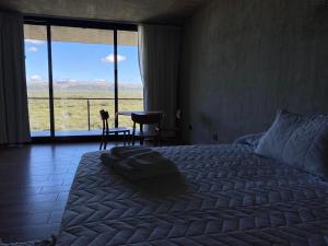 a bedroom with a bed and a large window with a view at Casa Sol in Villa Cura Brochero +25 photos