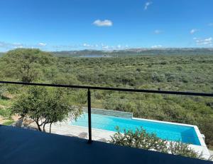 vistas a la piscina desde el balcón de una casa en Casa Sol en Villa Cura Brochero