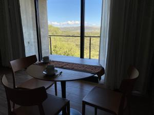 Habitación con mesa y ventana grande. en Casa Sol en Villa Cura Brochero