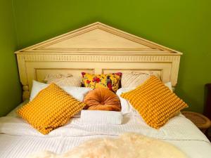 uma cama com almofadas amarelas e uma parede verde em Central Located 4BR Home with Rumpus & King Bed in the Heart of Melbourne em Chadstone