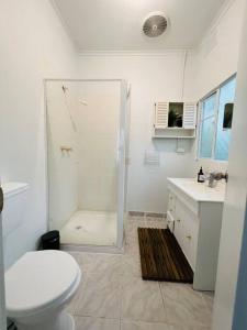 uma casa de banho com um chuveiro, um WC e um lavatório. em Central Located 4BR Home with Rumpus & King Bed in the Heart of Melbourne em Chadstone