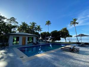 a swimming pool with two chairs and a house at coral coast FIJI in Sigatoka