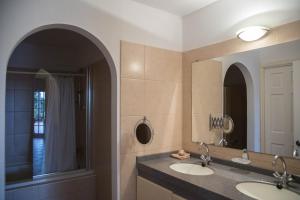 a bathroom with two sinks and a mirror at Casa Curacao Ocean Resort near Mambo Beach in Willemstad +40 photos