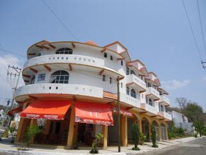 un edificio con sombrillas rojas y naranjas delante de él en Hotel CZ, en Santa Cruz Huatulco