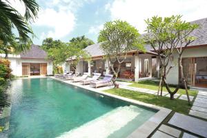 a swimming pool in the backyard of a house at Villa Bali Asri Batubelig in Seminyak