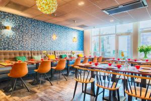 a restaurant with tables and chairs in a room at Leonardo Hotel Amsterdam City Center in Amsterdam