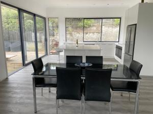 een keuken met een glazen tafel en zwarte stoelen bij Private Retreat Central Wanaka 2 Bedroom in Wanaka