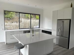 een witte keuken met een witte bar en een koelkast bij Private Retreat Central Wanaka 2 Bedroom in Wanaka