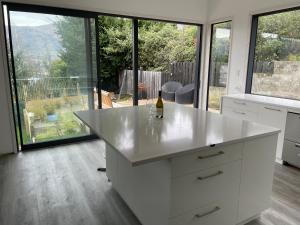 een witte keuken met een fles wijn op een aanrecht bij Private Retreat Central Wanaka 2 Bedroom in Wanaka