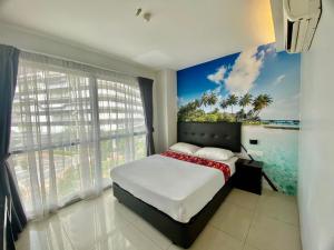 a bedroom with a bed with a painting of the ocean at Best View Hotel Sunway Mentari in Petaling Jaya