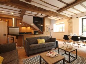 una sala de estar con un sofá y una mesa en Longère percheronne de charme avec équipements modernes, jardin, terrasse, vélos gratuits et espace adapté PMR - FR-1-497-77, en Ceton
