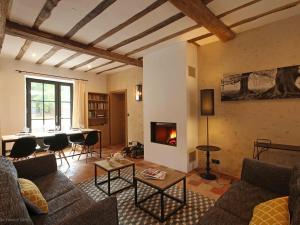 a living room with a couch and a fireplace at Gîte Ceton, 5 pièces, 9 personnes - FR-1-497-77 in Ceton