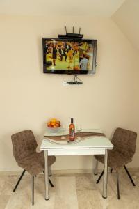 a white table with two chairs and a tv on the wall at Old Town Apartment 3 with Free Private Parking in Plovdiv